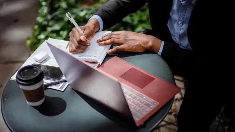 Persona treballant amb una llibreta i un ordinador / Ketut Subiyanto a Pexels